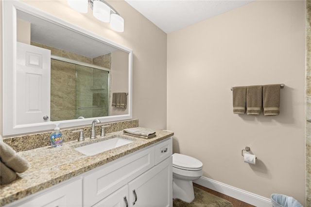 bathroom featuring walk in shower, vanity, and toilet