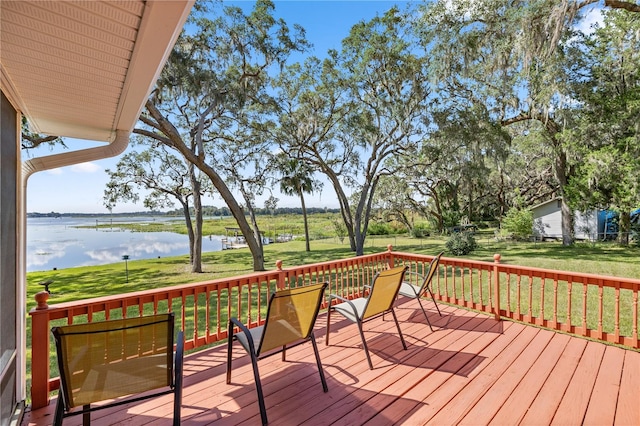 wooden deck with a lawn and a water view