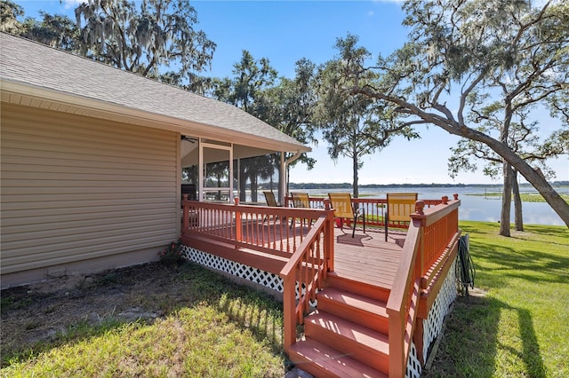 wooden terrace featuring a lawn and a water view