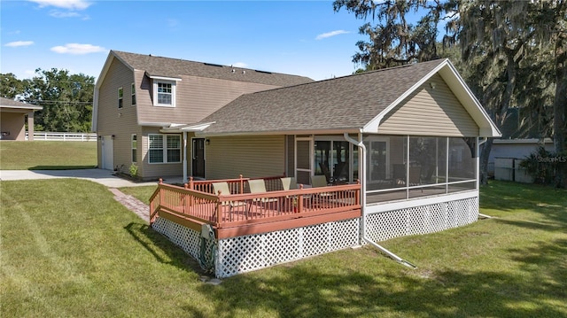 rear view of property with a yard, a sunroom, and a wooden deck