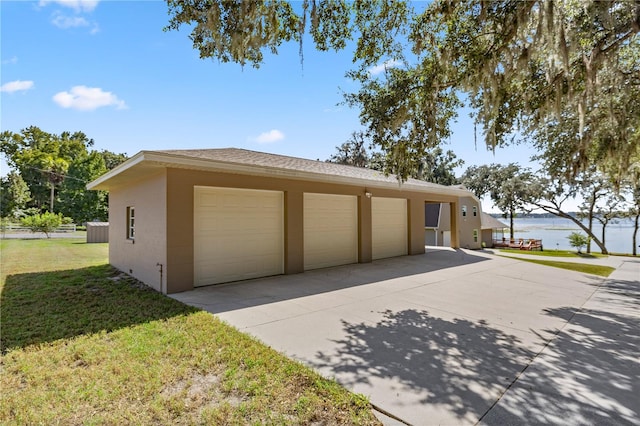 garage with a lawn and a water view