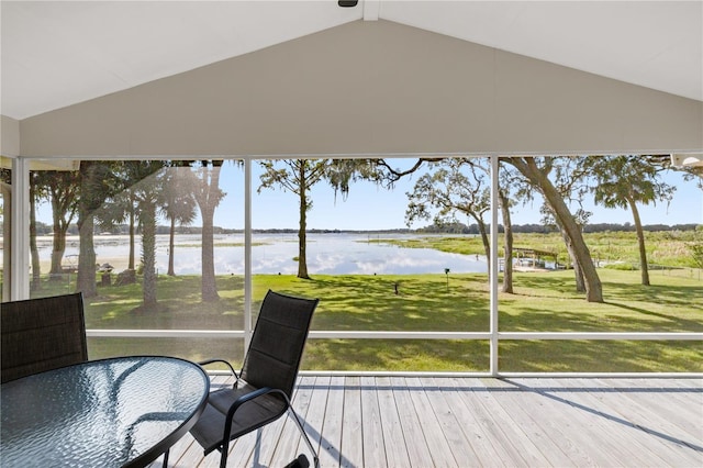 sunroom featuring a water view and vaulted ceiling