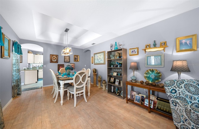 dining room featuring light hardwood / wood-style floors and a tray ceiling