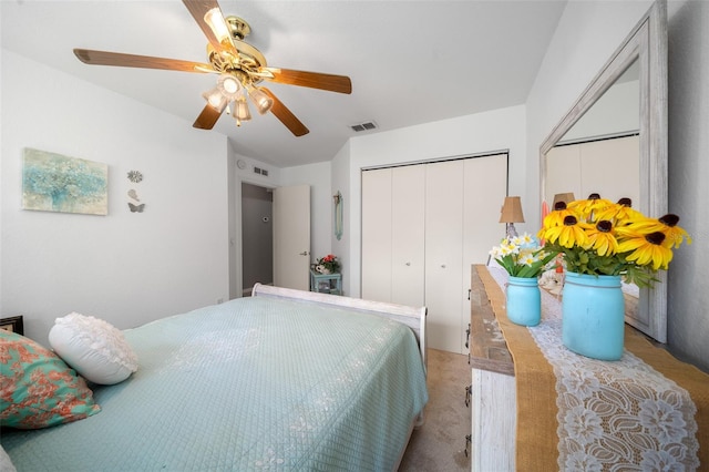 carpeted bedroom with ceiling fan and a closet