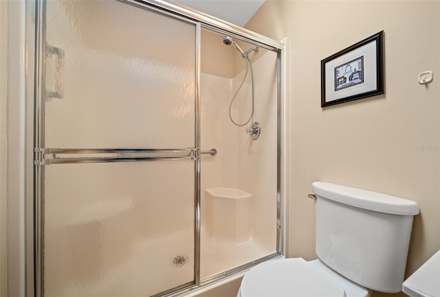 bathroom with toilet and an enclosed shower