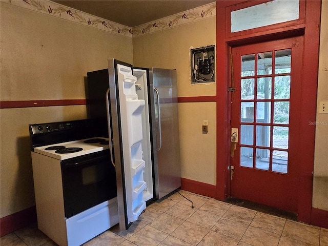 kitchen featuring stainless steel refrigerator, white electric range oven, and light tile patterned floors