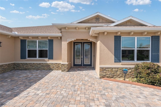 view of exterior entry featuring french doors and a patio area