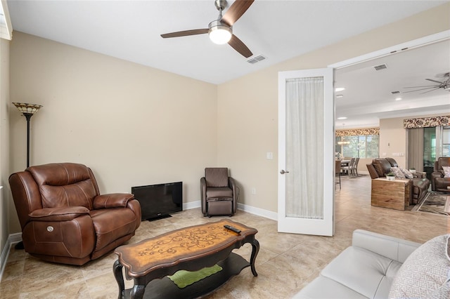 tiled living room featuring ceiling fan