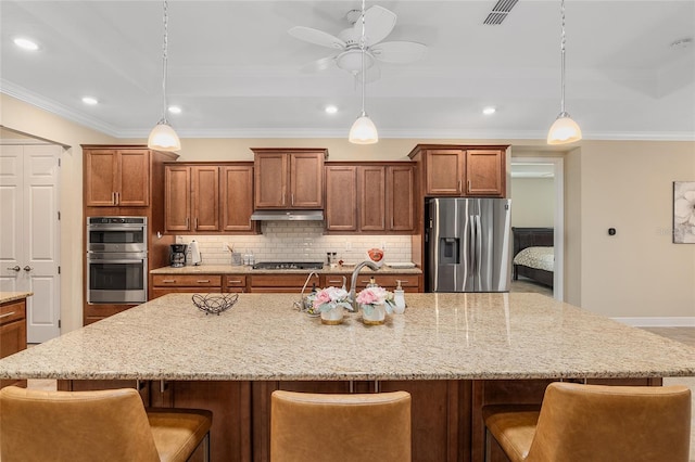 kitchen featuring pendant lighting, stainless steel appliances, and a breakfast bar