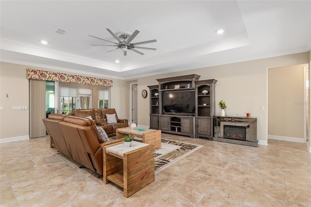 living room featuring crown molding, ceiling fan, and a raised ceiling