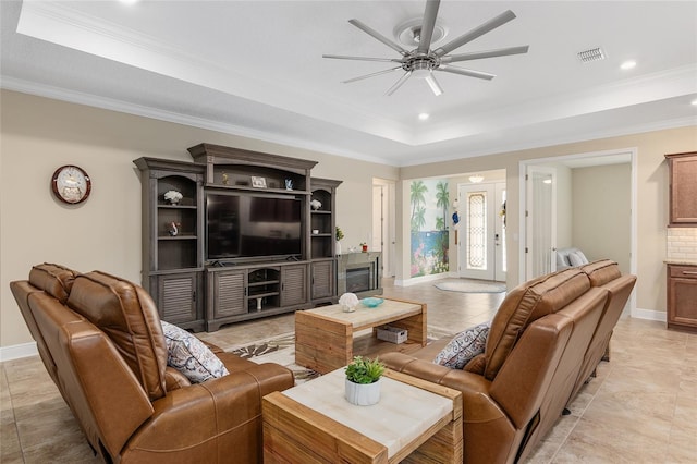 tiled living room featuring crown molding, ceiling fan, and a raised ceiling