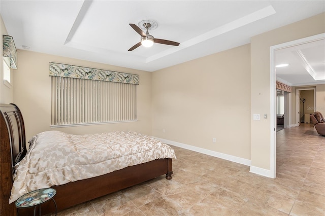 bedroom with ceiling fan and a raised ceiling