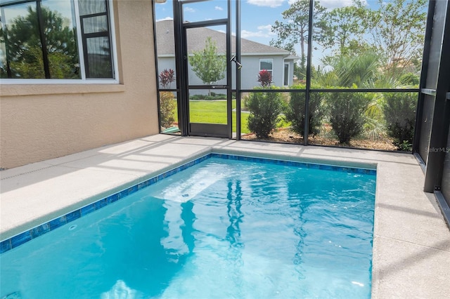 view of pool with glass enclosure and a patio