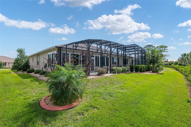 rear view of property with a yard and glass enclosure