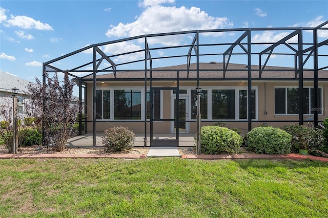 back of property with a patio area, a lawn, and a lanai