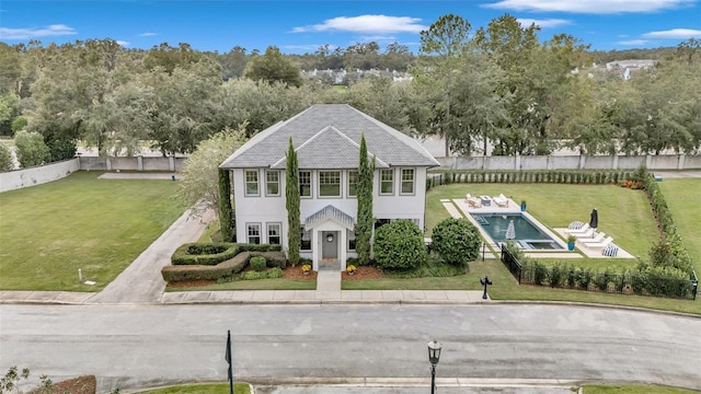 view of front of house with a fenced in pool and a front yard