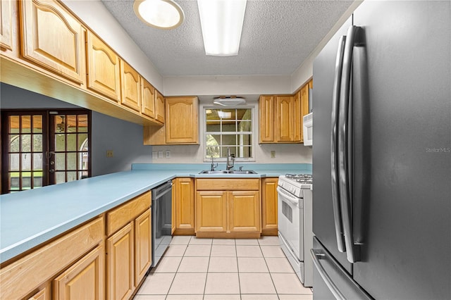 kitchen featuring french doors, sink, light tile patterned flooring, appliances with stainless steel finishes, and a textured ceiling