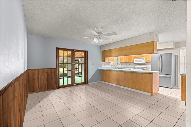 kitchen featuring sink, kitchen peninsula, white appliances, french doors, and a textured ceiling