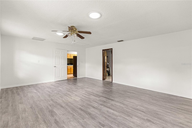 unfurnished room with wood-type flooring, a textured ceiling, and ceiling fan