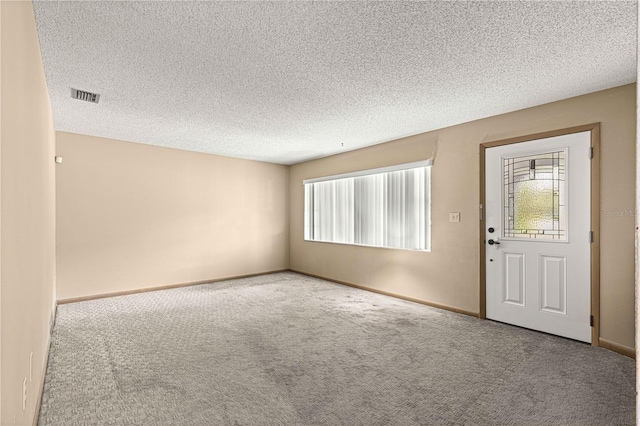 carpeted entryway featuring a textured ceiling and plenty of natural light