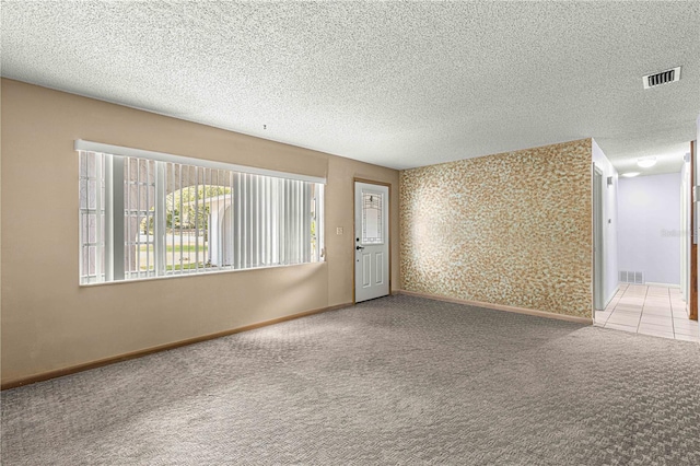 carpeted spare room with a textured ceiling