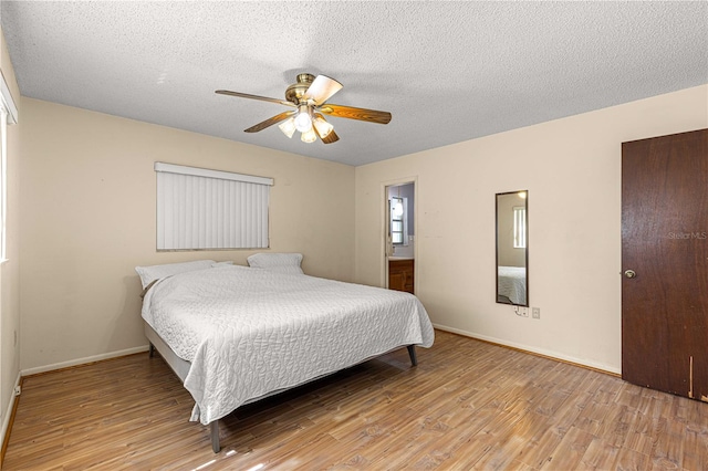 bedroom with light hardwood / wood-style floors, ensuite bathroom, a textured ceiling, and ceiling fan