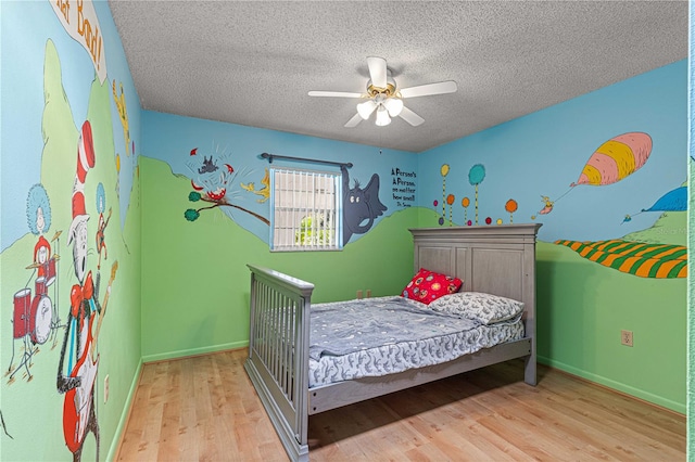 bedroom featuring a textured ceiling, light wood-type flooring, and ceiling fan