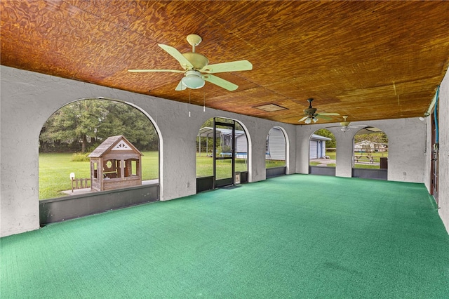 unfurnished sunroom with ceiling fan and vaulted ceiling