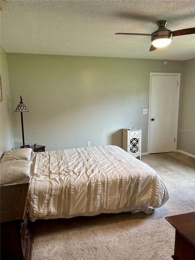 bedroom with a textured ceiling, carpet, and ceiling fan