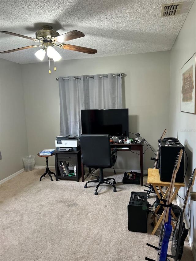 carpeted home office with ceiling fan and a textured ceiling