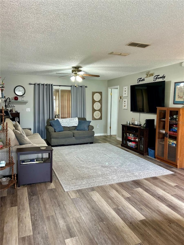 living room with wood-type flooring, a textured ceiling, and ceiling fan