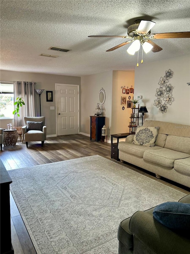 living room with ceiling fan, a textured ceiling, and hardwood / wood-style floors