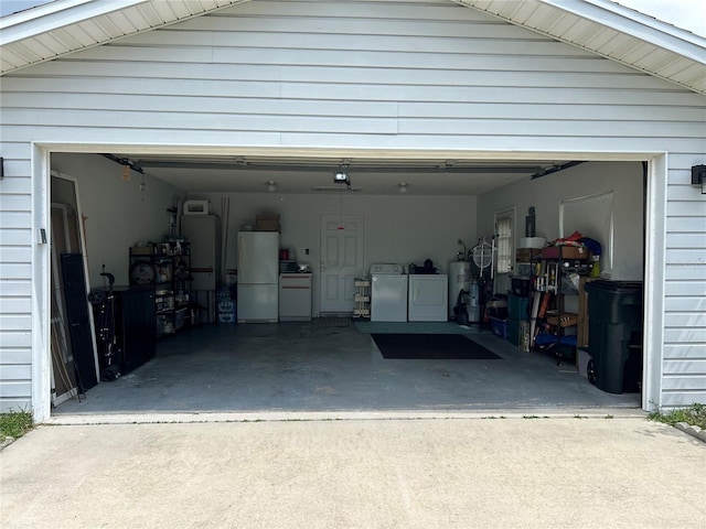 garage featuring water heater, white refrigerator, and independent washer and dryer