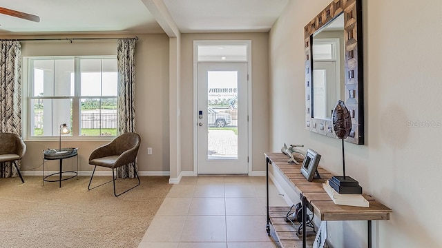 tiled foyer with beamed ceiling, ceiling fan, and plenty of natural light