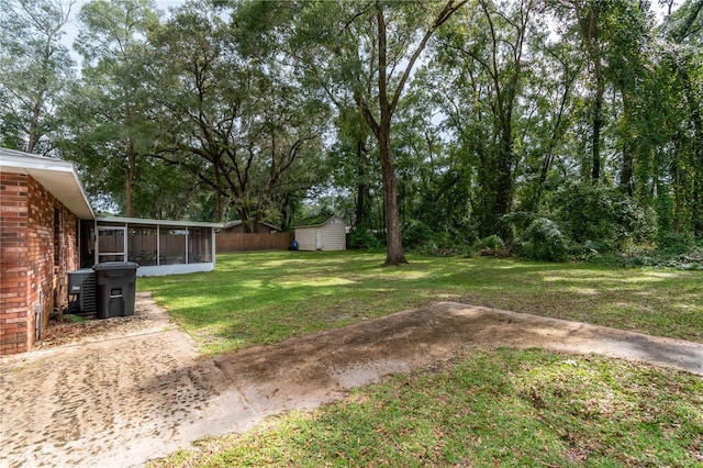 view of yard featuring a storage unit, a sunroom, and central air condition unit