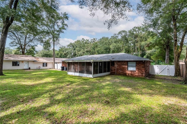 back of house featuring a yard and a sunroom