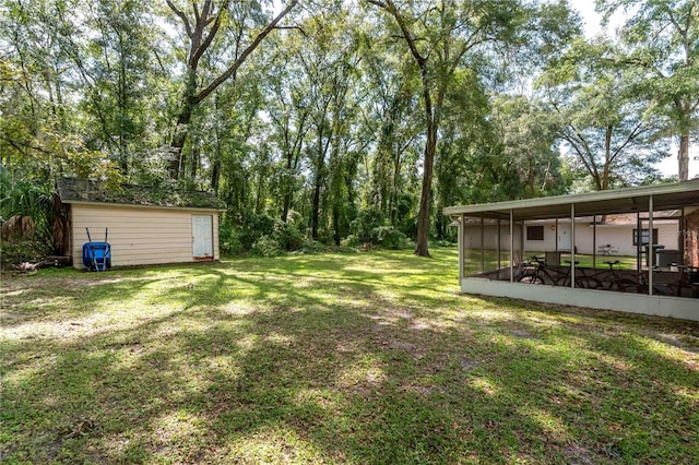 view of yard featuring a sunroom and an outbuilding