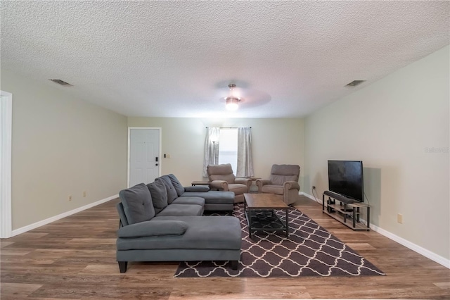 living room with a textured ceiling and hardwood / wood-style floors