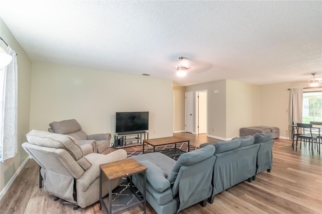 living room featuring a textured ceiling and light wood-type flooring