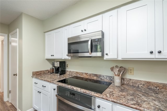 kitchen featuring stainless steel appliances, white cabinets, and stone counters