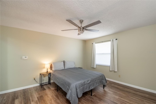 bedroom featuring ceiling fan, hardwood / wood-style floors, and a textured ceiling