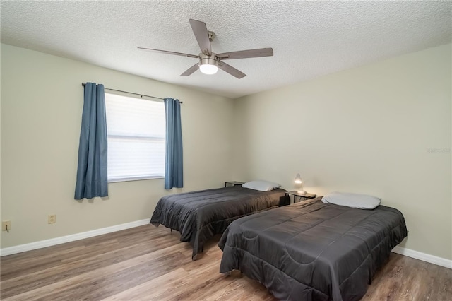 bedroom featuring a textured ceiling, hardwood / wood-style floors, and ceiling fan