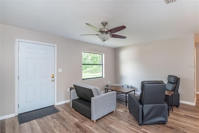 interior space with a textured ceiling, light hardwood / wood-style floors, and ceiling fan