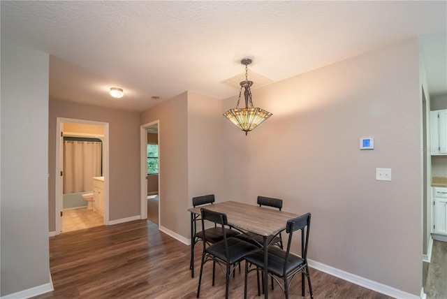 dining area featuring a textured ceiling and dark hardwood / wood-style flooring