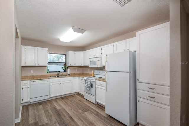 kitchen featuring white cabinets, light hardwood / wood-style flooring, sink, and white appliances