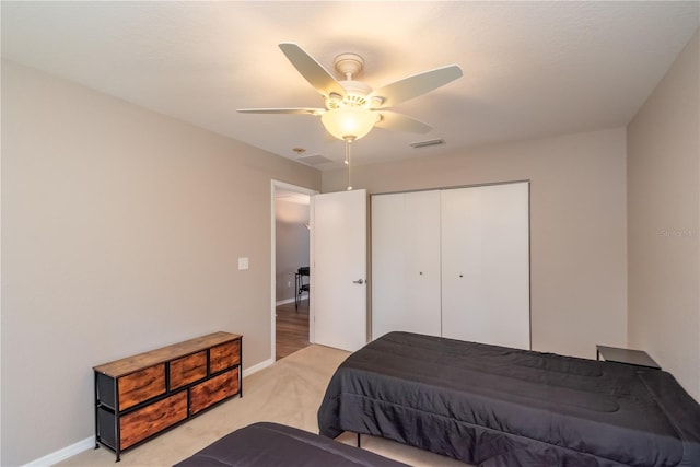 carpeted bedroom with ceiling fan and a closet