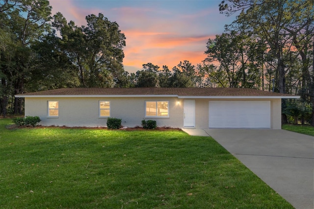 ranch-style house featuring a lawn and a garage