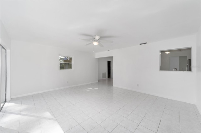 tiled empty room featuring ceiling fan