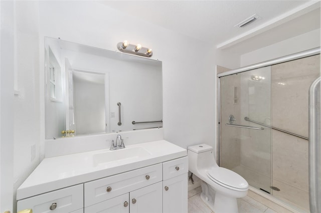 bathroom with tile patterned floors, a shower with shower door, vanity, and toilet