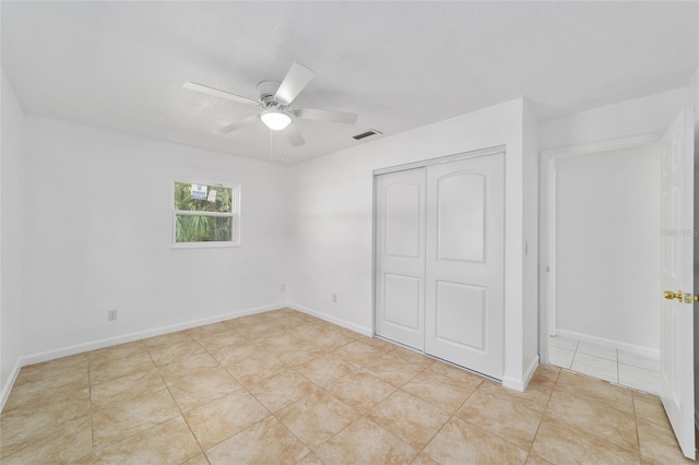 unfurnished bedroom featuring ceiling fan, a closet, and light tile patterned floors